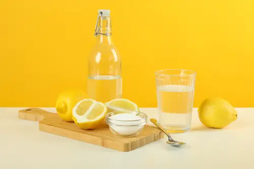 Composition with household cleaners on white table against yellow background